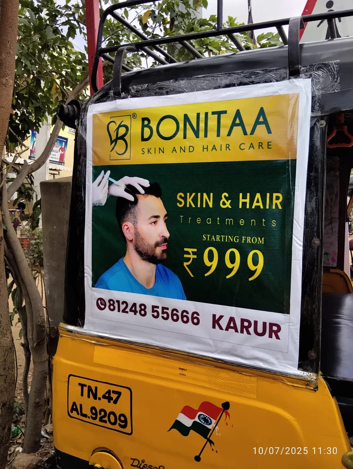 Auto-rickshaw back panel carrying a salon ad