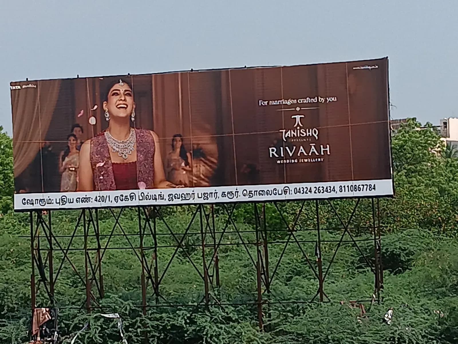 Wide jewellery hoarding above greenery