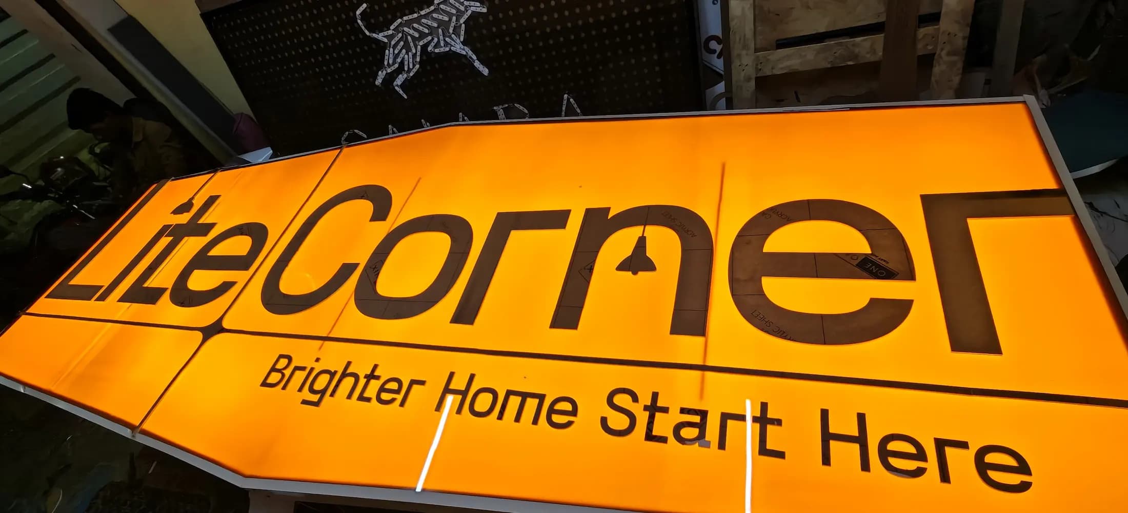 Bright orange glow-sign shop board seen from below