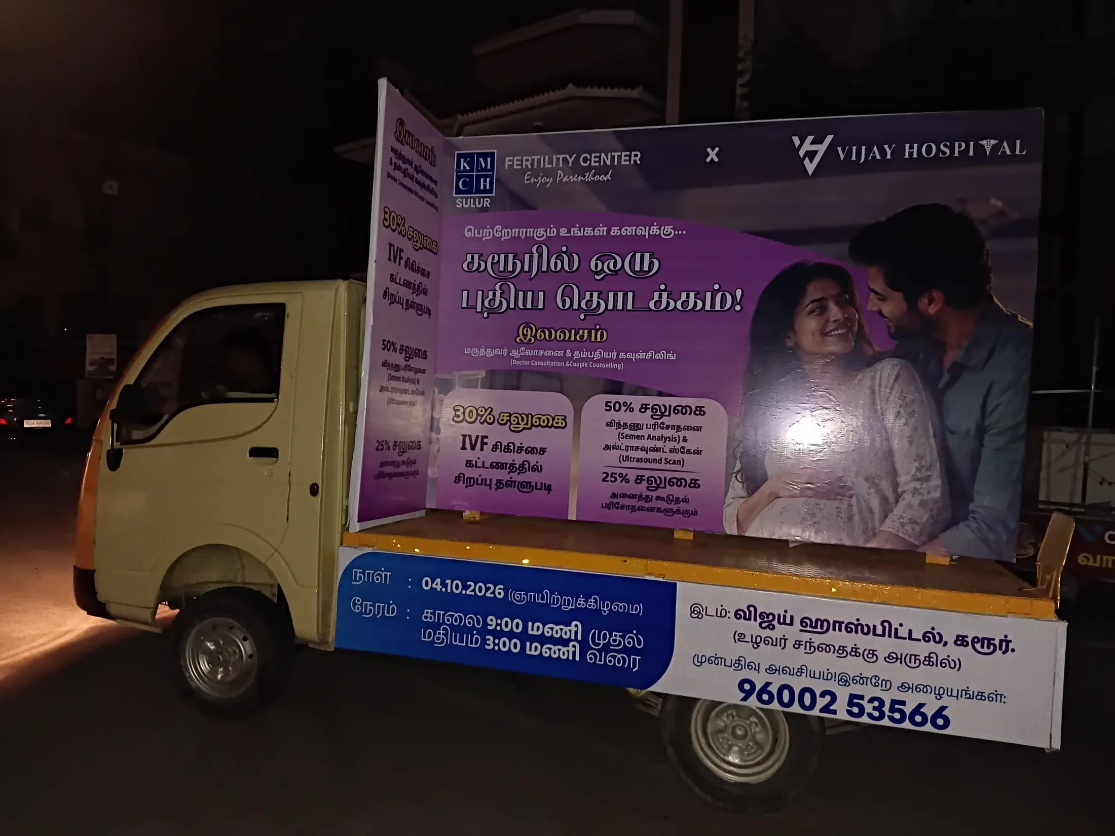 Mini-truck with an illuminated campaign panel parked at night