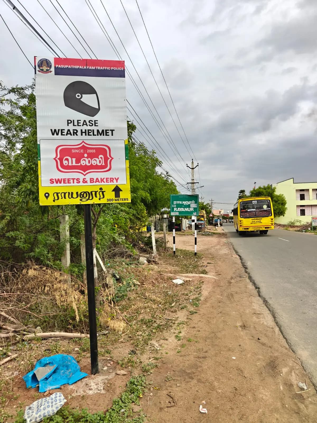 Roadside helmet-safety pole sign sponsored by sweets & bakery
