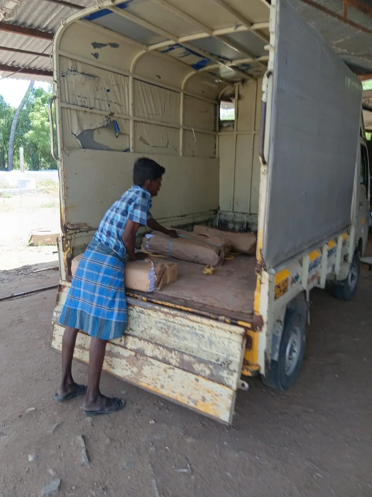 Worker loading pamphlet bundles into goods vehicle